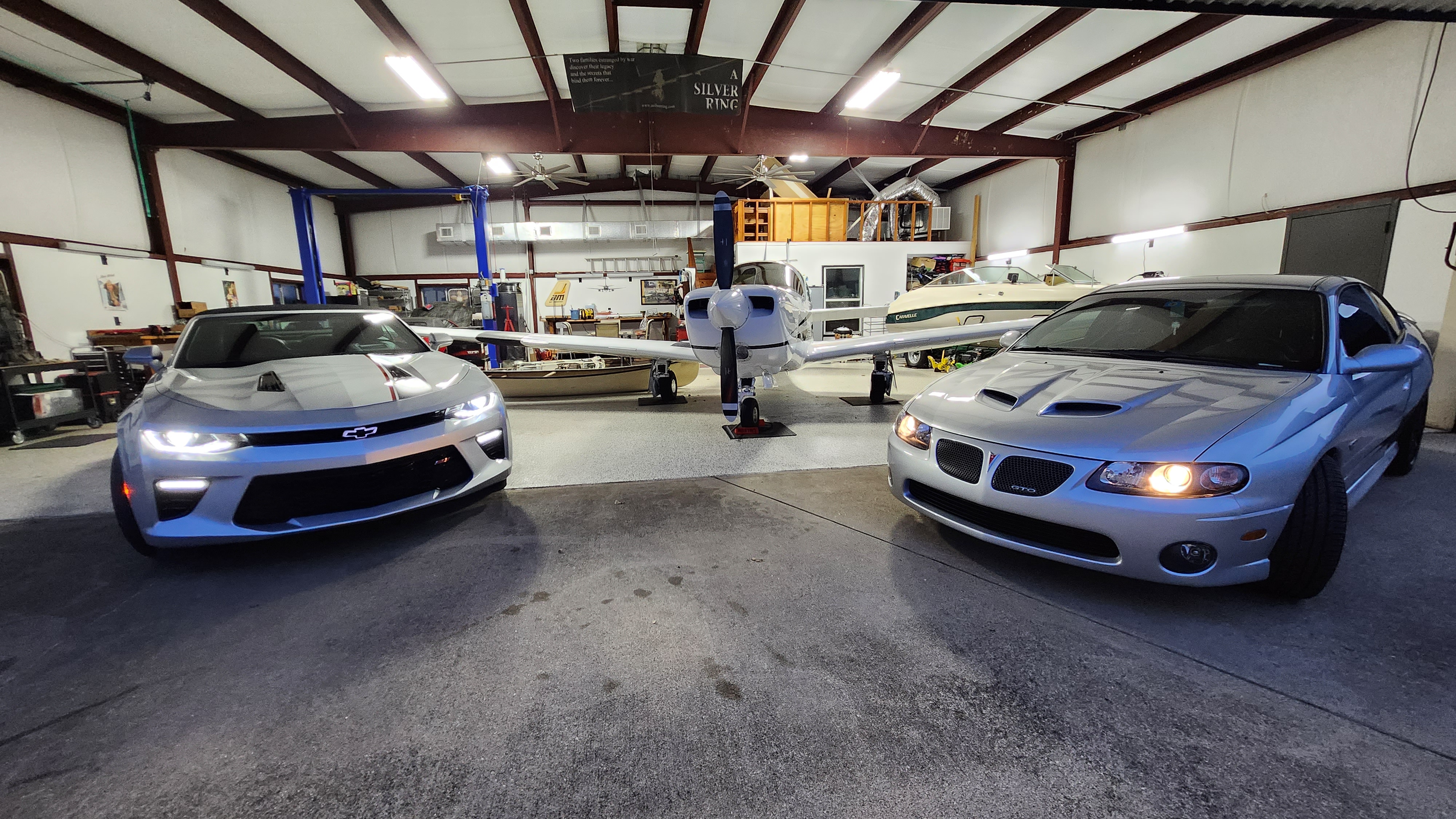 Hangar interior with Camaro, GTO, Mooney, lift and loft visible