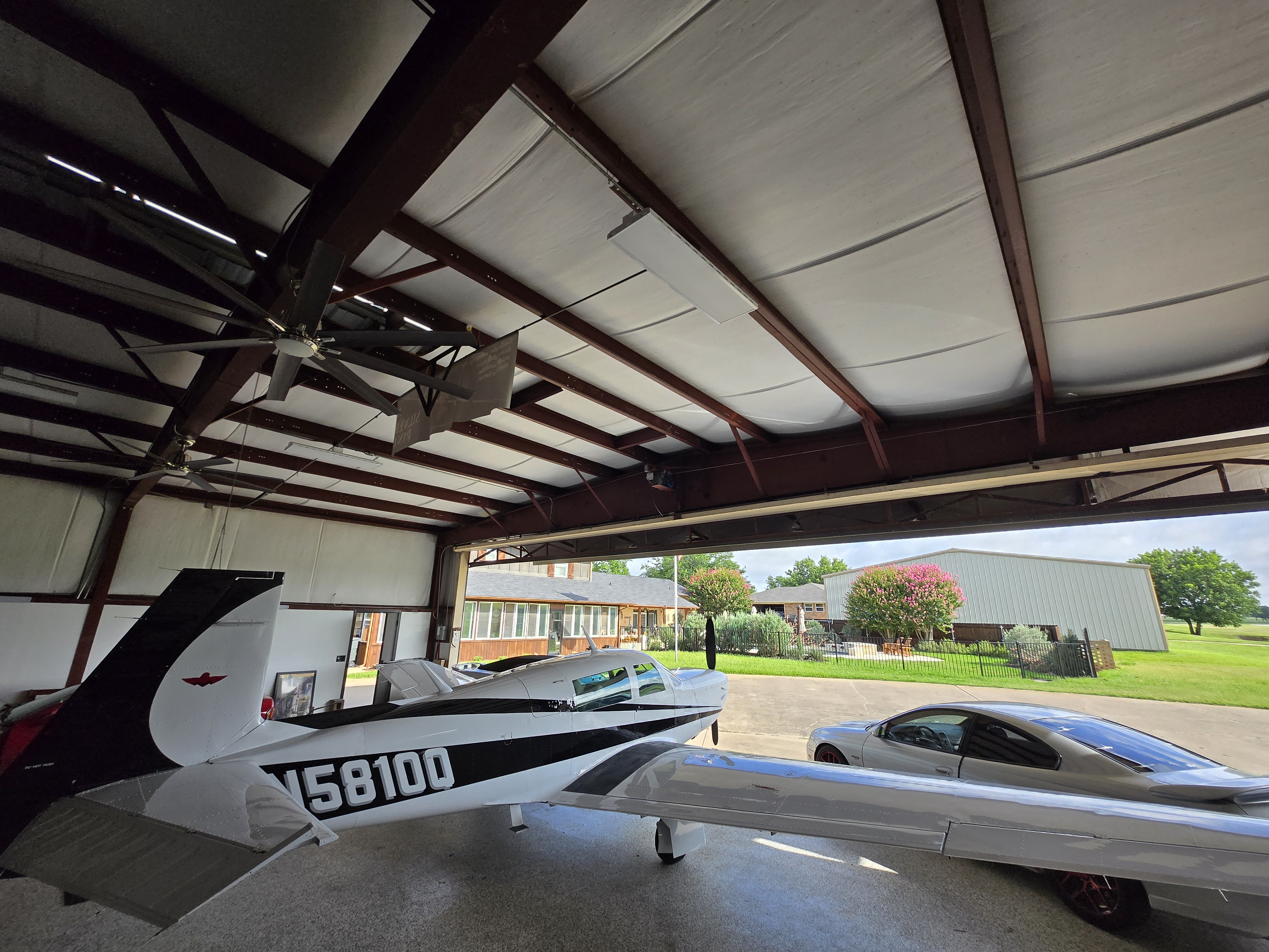 View from inside hangar looking out toward house and runway