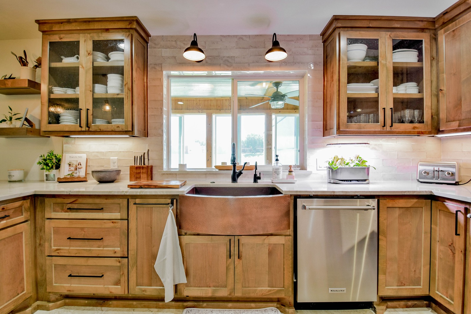 Hammered copper farmhouse sink, knotty alder cabinets, quartzite counters, travertine backsplash
